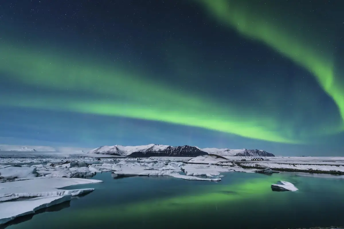 The Aurora Borealis (Northern Lights) dancing over the icy landscapes of Iceland.