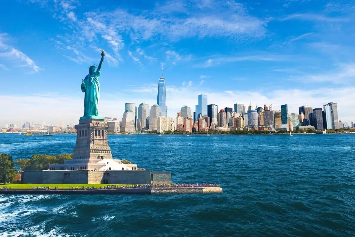 The Statue of Liberty on Liberty Island in front of the Manhattan skyline.