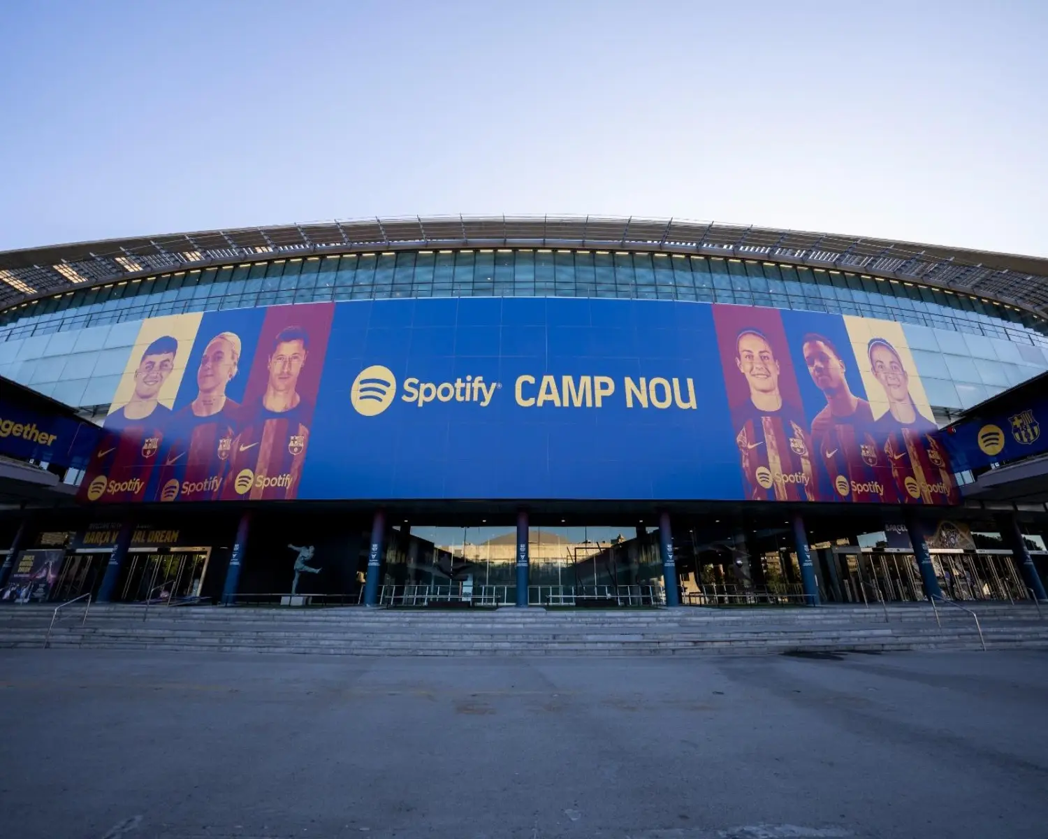 The facade of the Spotify Camp Nou Stadium in Barcelona, Spain featuring a large banner with FC Barcelona players.