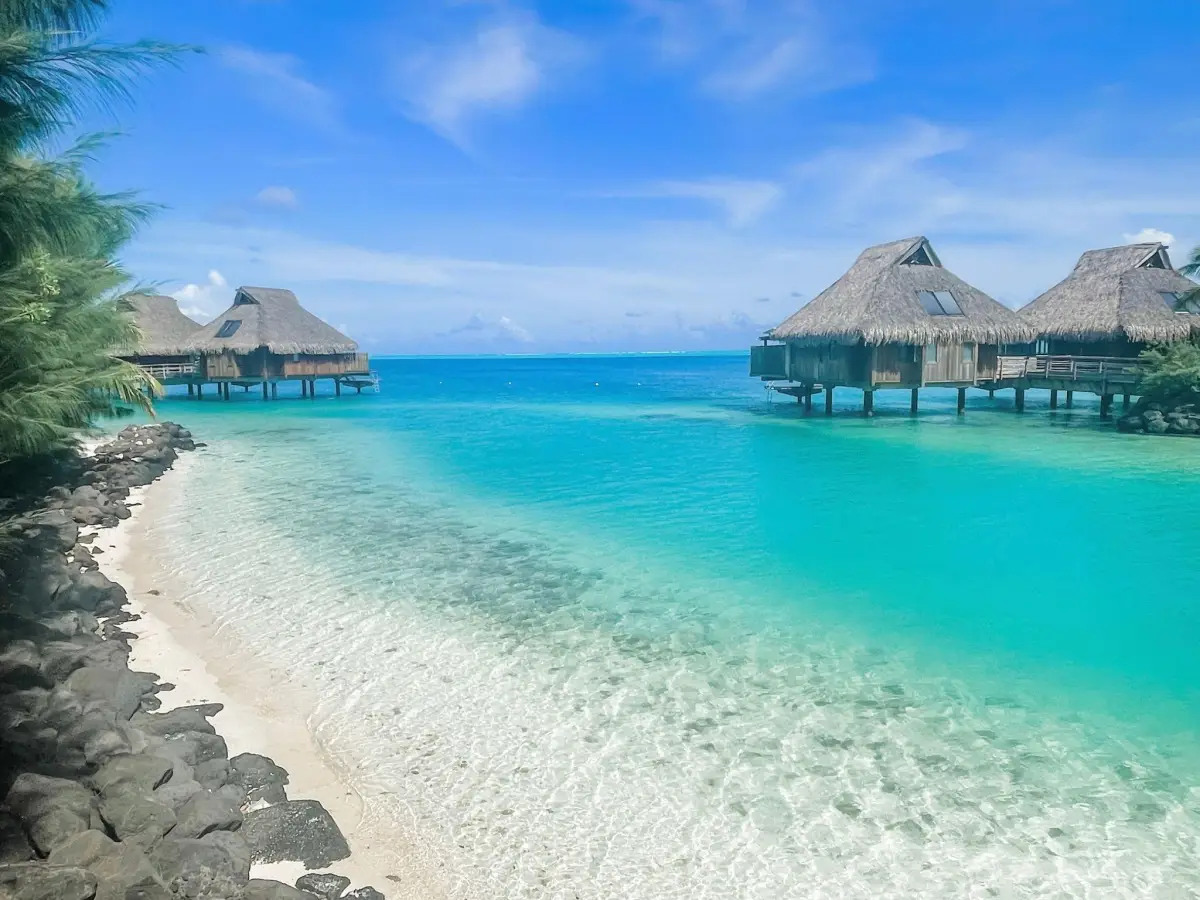 These traditional, thatched-roof Polynesian huts extend directly out from the southern tip of the main island at Matira Point.