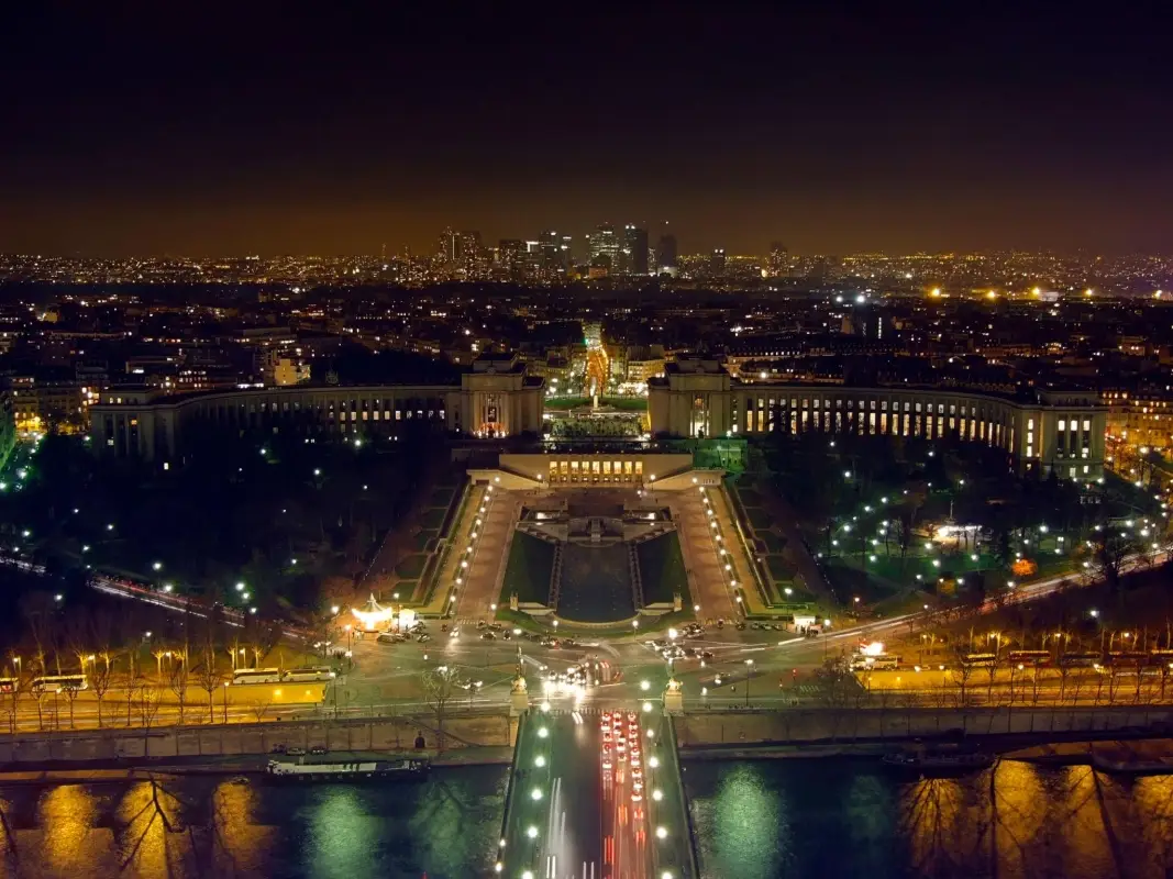 The Palais de Chaillot from the Eiffel Tower, with the La Defense business district illuminated in the background.