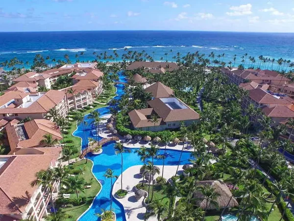 Aerial view of the large outdoor lagoon pool and tropical palm tree grounds at Majestic Colonial Punta Cana resort.