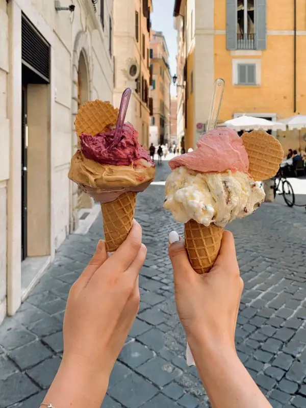 Authentic Italian gelato held against the backdrop of a charming Roman street.