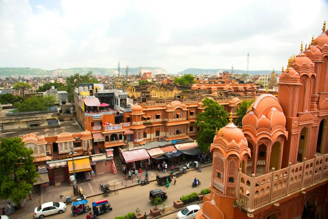High angle view of the Hawa Mahal palace, a UNESCO World Heritage site, overlooking a busy street market in Jaipur, India.