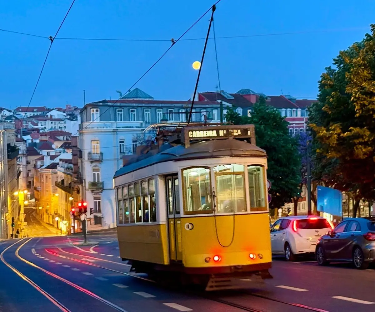 Vintage yellow Tram 28 operating at twilight in Lisbon, Portugal.