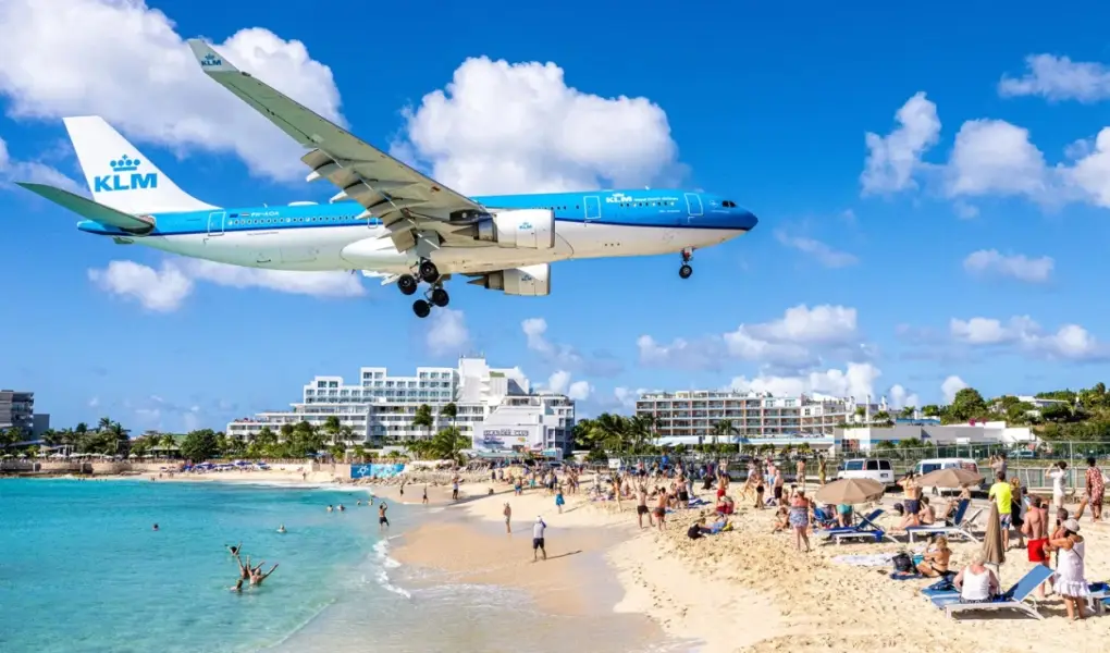 KLM airplane flying extremely low over tourists on Maho Beach in Sint Maarten.