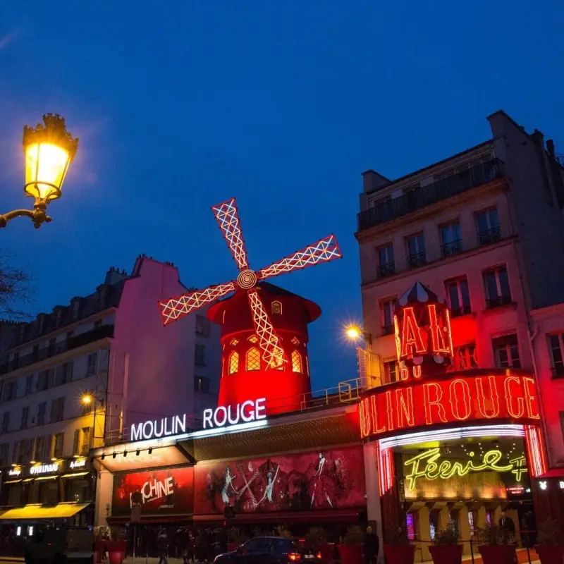 Moulin Rouge, a cabaret in Paris, on the Boulevard de Clichy, at the Place Blanche, the intersection and end of the Rue Blanche.