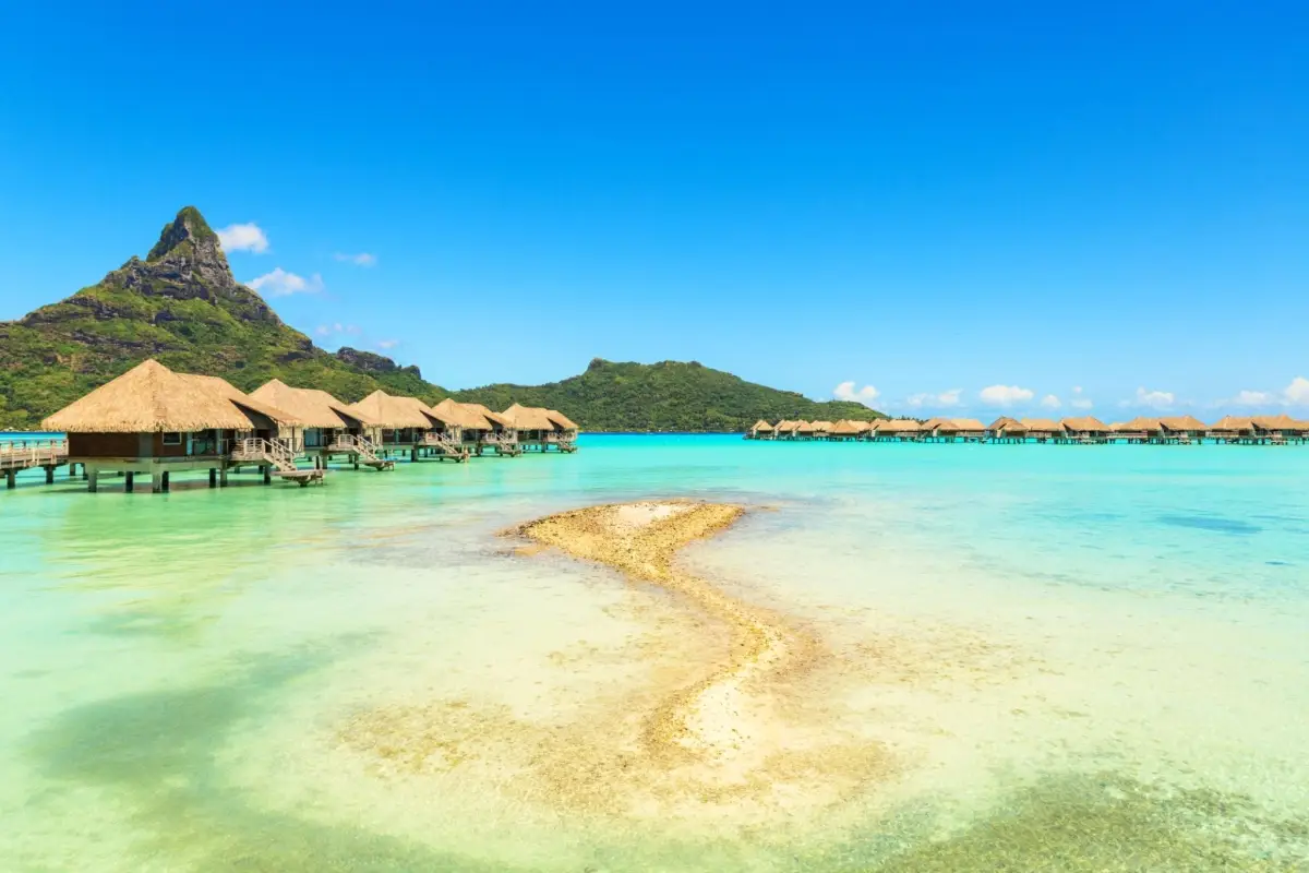 A stunning tropical scene in Bora Bora, French Polynesia, highlighted by the majestic Mount Otemanu rising prominently in the background.