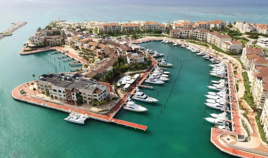 Aerial view of Cap Cana Marina in Punta Cana, Dominican Republic, a luxury destination characterized by its Mediterranean-style architecture and numerous docked luxury yachts.