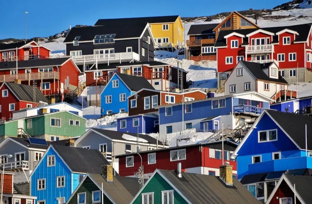 Colorful wooden houses built on a snowy hill in Qaqortoq, South Greenland.