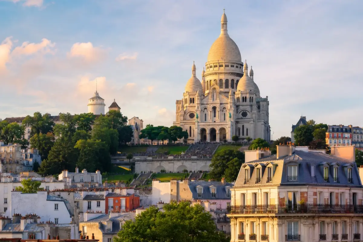 Montmartre is a distinct, village-like hill in Paris famous for its bohemian history, cobblestone streets and sweeping city views and is crowned by the iconic Sacre Coeur Basilica.