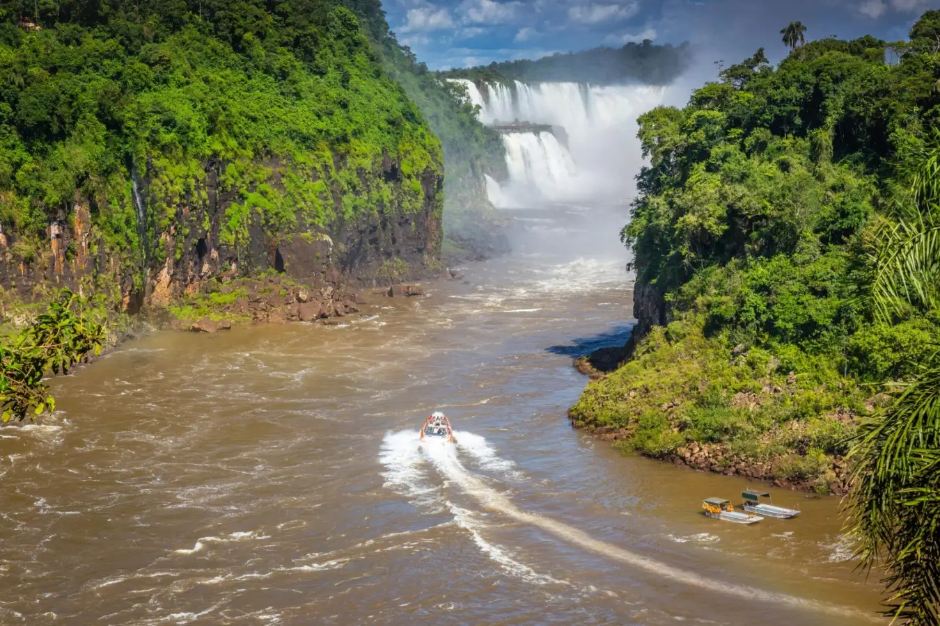 A speed boat navigating the Iguazu River towards Iguazu Falls in South America, located on the border between Argentina and Brazil.