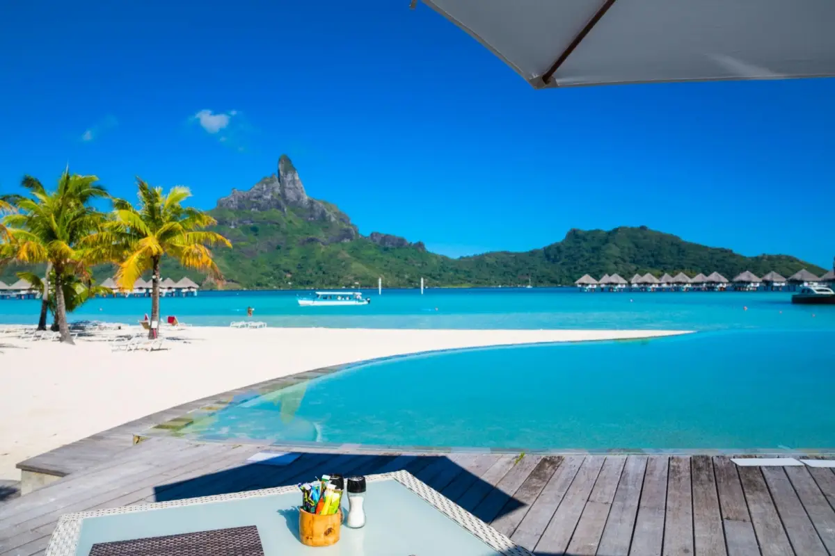 Luxury tropical beach resort in Bora Bora with a view of Mount Otemanu across the turquoise lagoon.